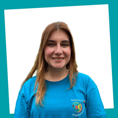 jrk-nds_jrk-landesgeschaeftsstelle_celina-voss_02.jpg Porträt einer lächelnden Kontaktperson des Jugendrotkreuzes Niedersachsen in einem blauen JRK-T-Shirt