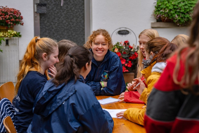 JRK-Mitglieder sitzen im Freien an einem Tisch.