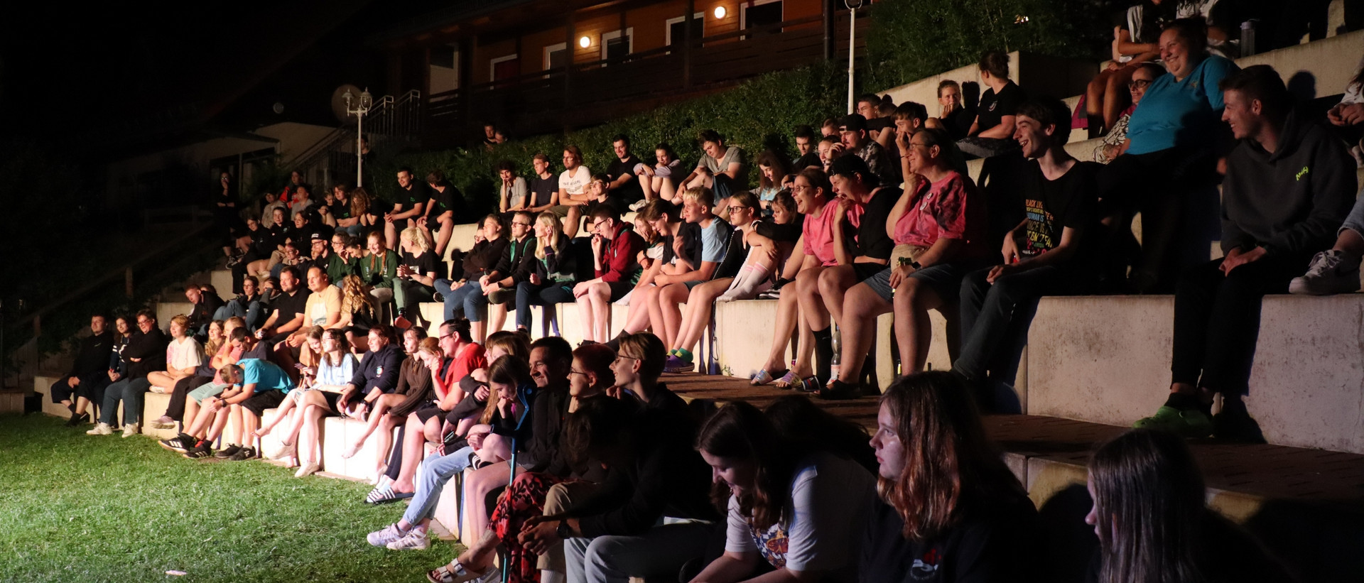 Bei der Preisverleihung des Nachtorientierungslauf sitzt das Publikum aus JRK-Mitgliedern auf einer Tribüne.
