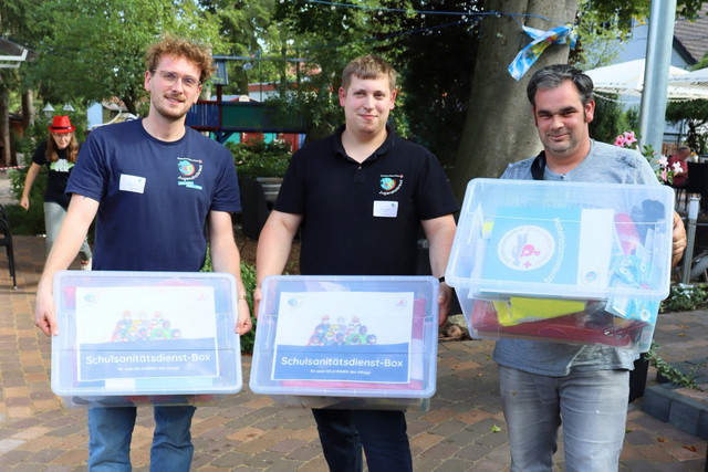 JRK-Mitglieder präsentieren drei Boxen für den Schulsanitätsdienst.