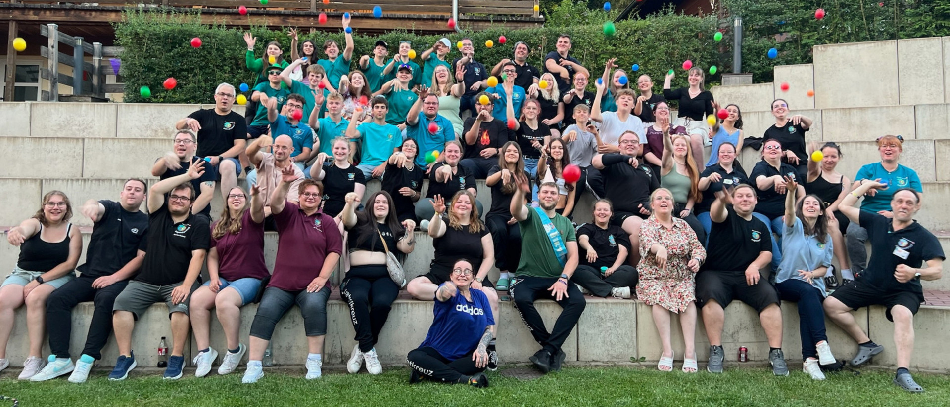 Bei einem Gruppenbild vom Cross Media Festival werfen die JRK-Mitglieder Bälle in Richtung Kamera.