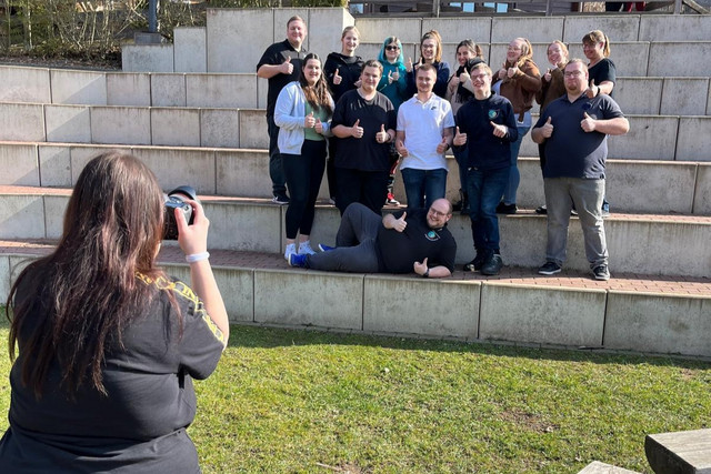Eine Jugendliche macht ein Foto von einer JRK-Gruppe.