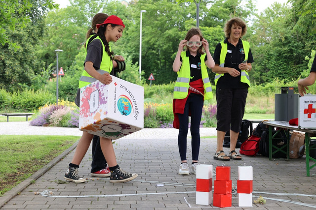 Ein JRK-Mitglied trägt einen großen Würfel bei einer Aufgabe eines JRK-Wettbewerbs.
