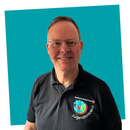 jrk-nds_jrk-landesgeschaeftsstelle_stefan-eck Porträt einer lächelnden Kontaktperson des Jugendrotkreuzes Niedersachsen in einem schwarzen JRK-T-Shirt.“