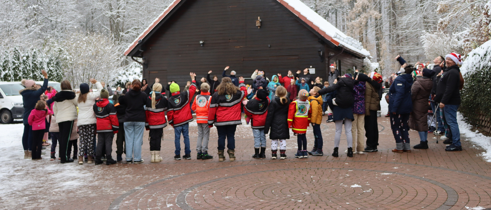 Die Teilnehmenden des Winterzauber machen bei Schnee ein Warm-Up im Kreis.