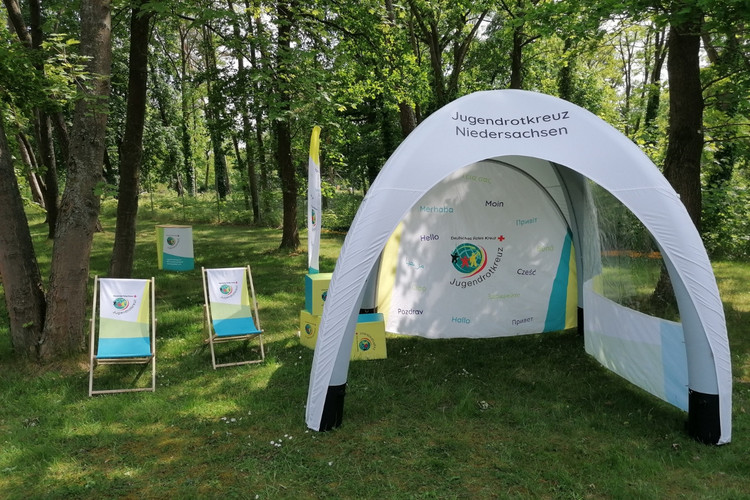 Pop-Up Store - Zelt Ein aufblasbares Zelt mit einer Seitenwand und einer Wand mit Fenster. Es hat einen JRK-Schriftzug und das JRK-Logo.
