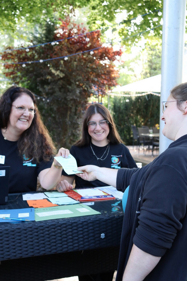 Anmeldung - Teaserbild Teilnehmende melden sich bei einer JRK-Veranstaltung am Infostand an.