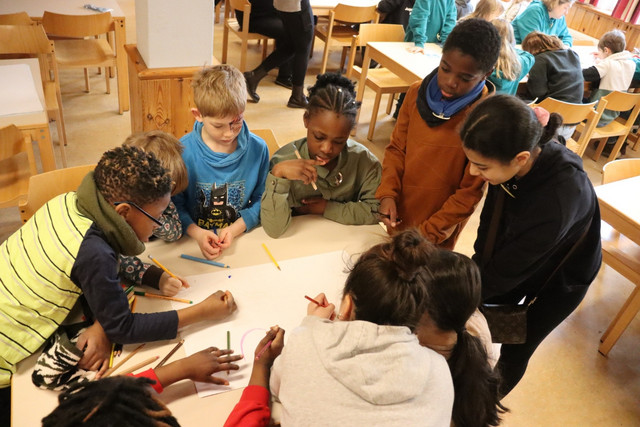 Kinder gestalten beim Landeskindertreffen gemeinsam ein Plakat.