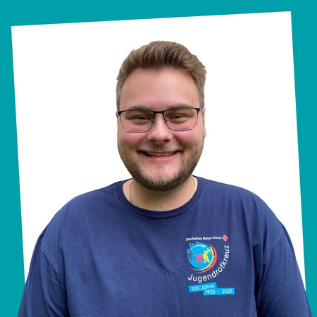 jrk-nds_jrk-landesgeschaeftsstelle_pascal-sablottny_02.jpg Porträt einer lächelnden Kontaktperson des Jugendrotkreuzes Niedersachsen in einem blauen JRK-T-Shirt