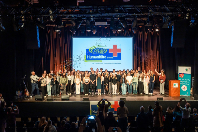 Ein großes Gruppenfoto mit Konfetti von der Zertifizierungsfeier der Humanitären Schule.