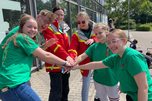 JRK-Gruppenleitungen haben einen Kreis gebildet und die Hände in die Mitte gestreckt.