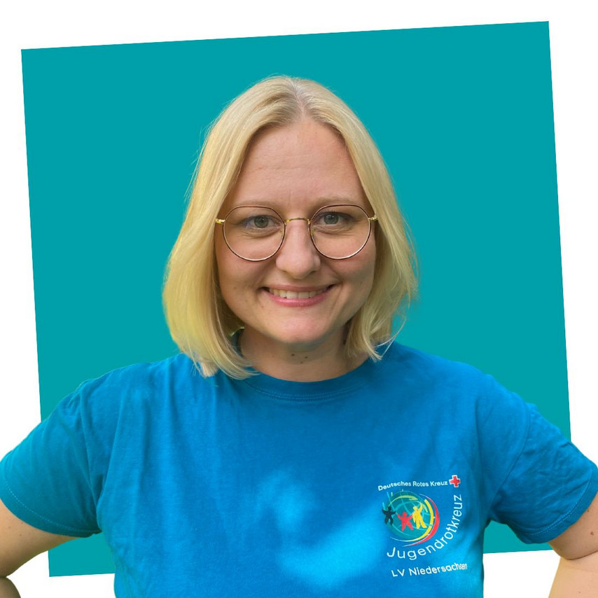 Porträt einer lächelnden Kontaktperson des Jugendrotkreuzes Niedersachsen in einem petrolfarbenen JRK-T-Shirt.
