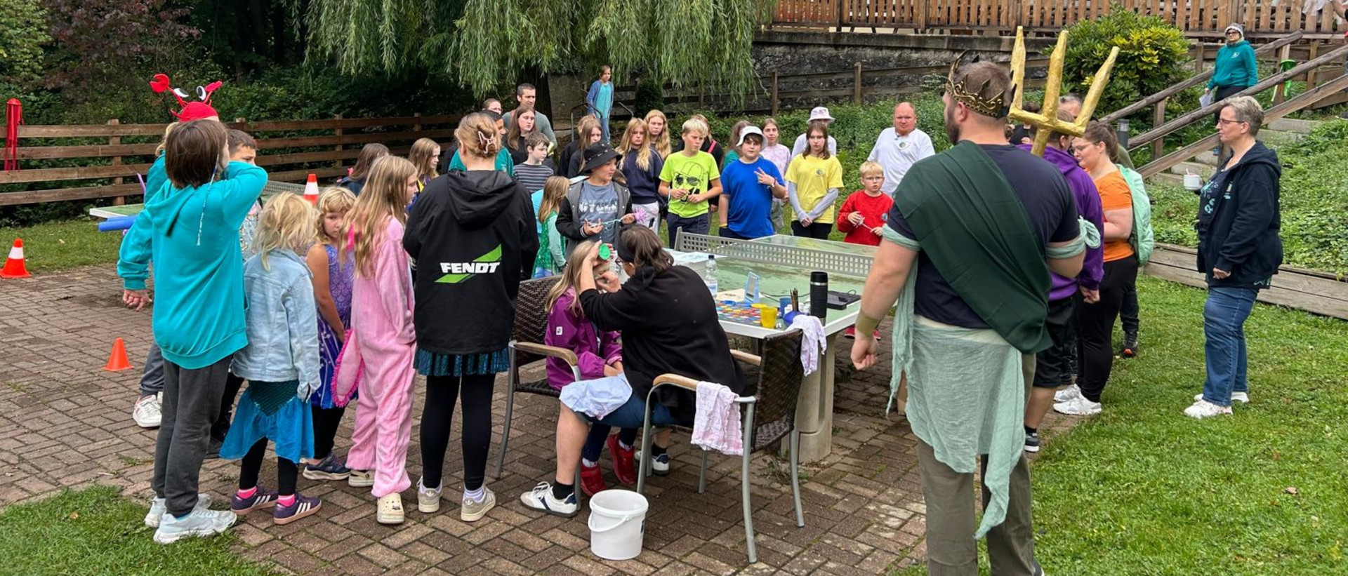Eine große Gruppe JRK-Mitglieder im Innenhof des Haus des Jugendrotkreuzes bei einem Abendorientierungslauf.