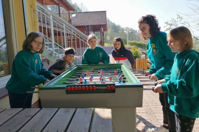 Eine JRK-Gruppe spielt beim Tischkicker-Spiel im Freien.